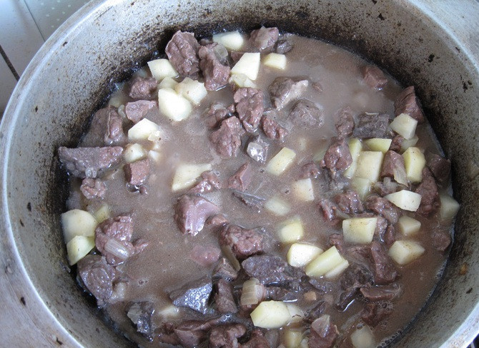 1. Этап. Куурдак из легких: Картофель режем кубиками и кладем в казан, тушим все под крышкой 20 минут, время от времени помешивая.