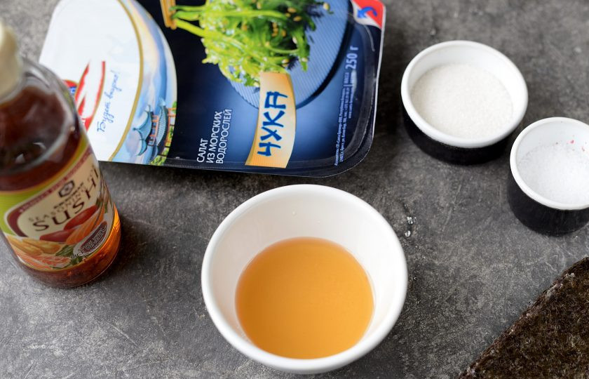 1. Этап. Роллы с чукой: Приготовьте заправку для риса. Для этого смешайте уксус, соль и сахар в небольшой емкости. Поставьте на несколько секунд в микроволновку, чтобы уксус слегка подогрелся, а кристаллы соли и сахара растворились.