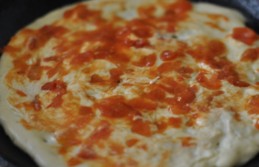 1. Этап. Пицца на сковороде с ветчиной: Теперь смазываем сковороду небольшим количеством масла и выкладываем на нее тесто, равномерно его распределяем. Смазываем основу томатным соусом, посыпаем базиликом и орегано.