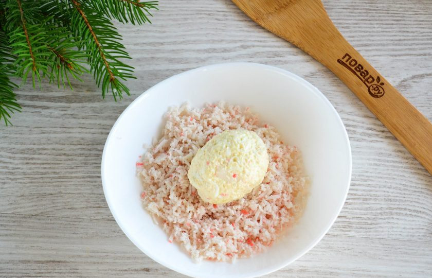 1. Этап. Закуска на год Крысы: Из полученной массы сформируйте шарики, придайте им форму яйца, обваляйте в натертых крабовых палочках, которые мы оставляли ранее.