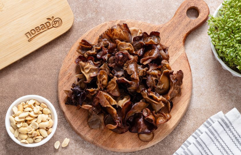 1. Этап. Закуска с древесными грибами и арахисом: После слейте воду, а грибы тщательно промойте в чистой воде несколько раз — на них может быть земля и мусор. Отрежьте плодоножку со всех грибов и нарежьте их на кусочки среднего размера.