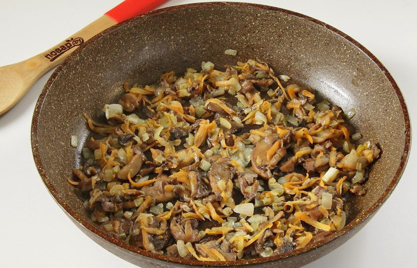 1. Этап. Фаршированные кальмары: 4. Добавьте грибы и продолжайте готовить до испарения жидкости.