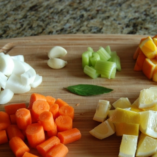 1. Этап. Курица с овощами в цитрусовом соусе: Кубиками примерно одинакового размера нарежем морковь, лук, апельсин, лимон, сельдерей. Зубчики чеснока просто очистим.