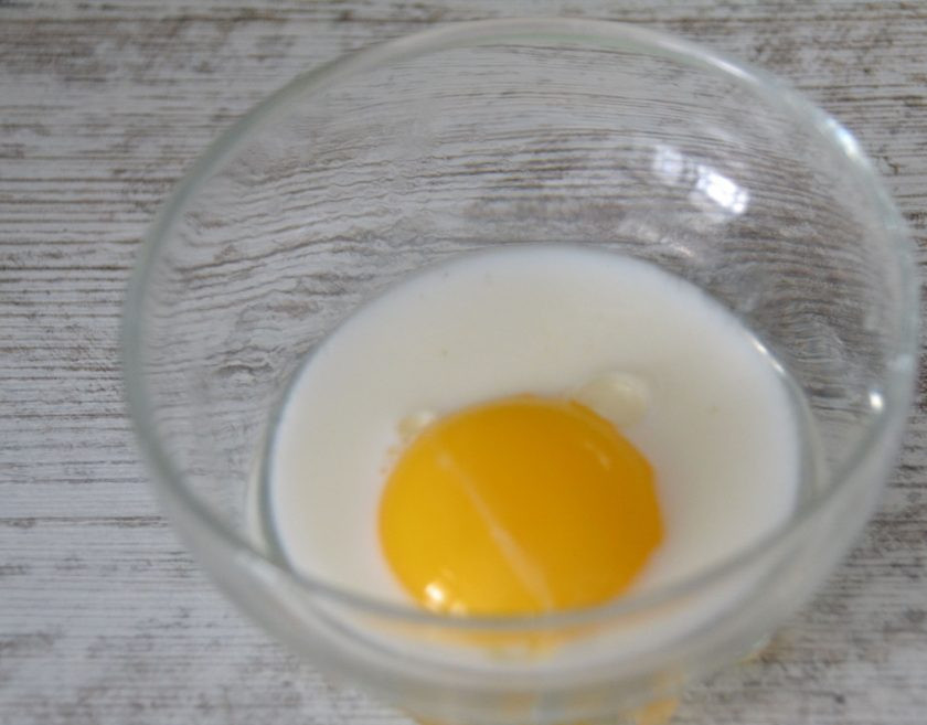 1. Этап. Булочки с конфетами Коровка: Взболтайте яичный желток со столовой ложкой молока.