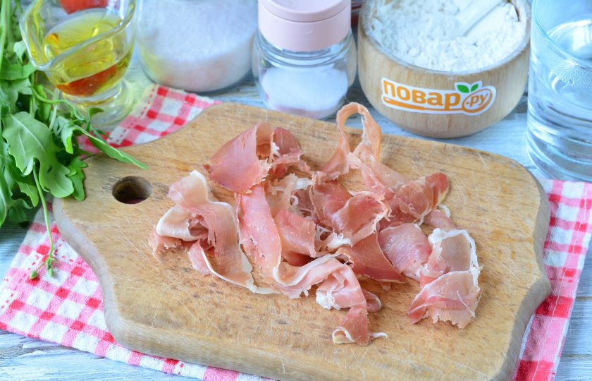 1. Этап. Пицца с прошутто и рукколой: Прошутто порвите руками на средние полоски.