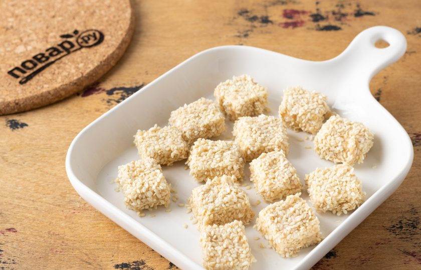 1. Этап. Хрустящий тофу в кунжуте: Смажьте форму для выпечки растительным маслом. Выложите тофу. Запекайте его в разогретой до 180 градусов духовке 10 минут. Затем переверните и готовьте ещё 10-15 минут.