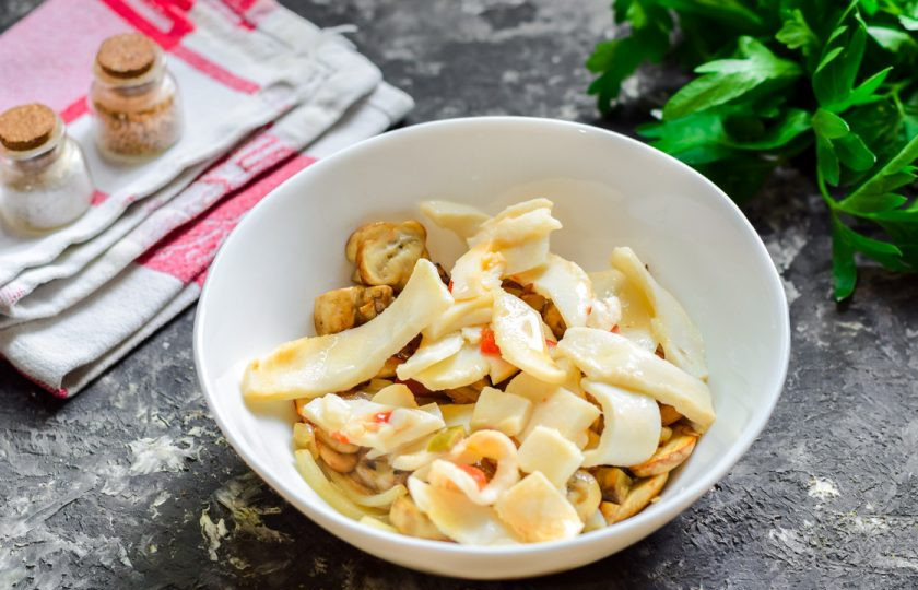 1. Этап. Салат Кальмаровый пир: Грибы переложите в салатник. Добавьте в салат кальмары.