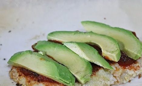 1. Этап. Курица с авокадо под сырной шубкой: Когда курица дойдет до полуготовности, немного остудите ее. Затем смажьте томатным соусом, сверху выложите тонкие дольки авокадо.