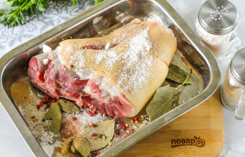 1. Этап. Айсбайн: Тщательно промойте свиную рульку в воде. Можно использовать как задние, так и передние ноги, по желанию. Тщательно соскоблите всю грязь острым ножом, еще раз промойте рульку в воде и выложите на противень с высокими бортиками. Всыпьте соль и вотрите ее в мясо. Добавьте на противень лавровые листья, горошины черного и белого перца, молотый черный перец.