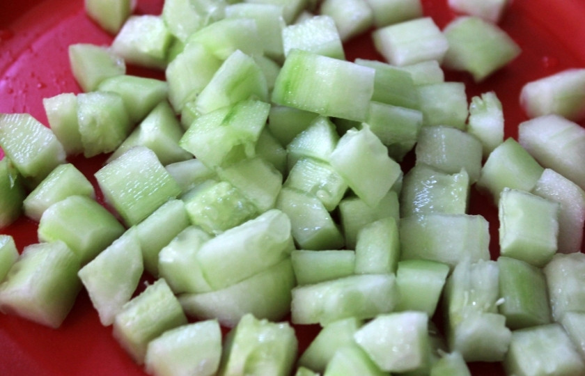 1. Этап. Макароны с огурцами: Очистите огурец от кожуры и нарежьте кубиками.