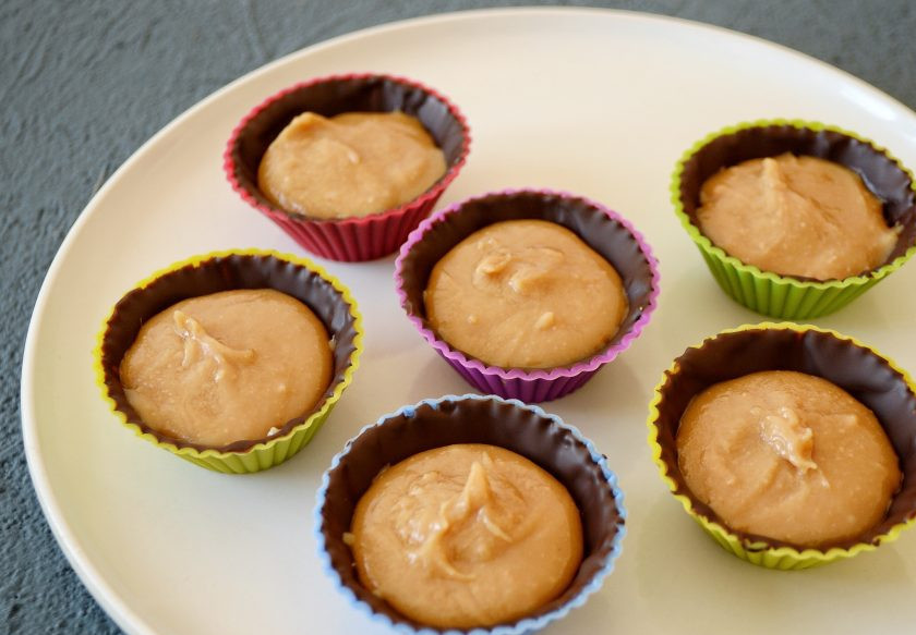 1. Этап. Конфеты с арахисовой пастой: В центр конфет выложите арахисовую пасту, заполните формочки на 3/4. Поставьте в морозильную камеру ещё на 10 минут.