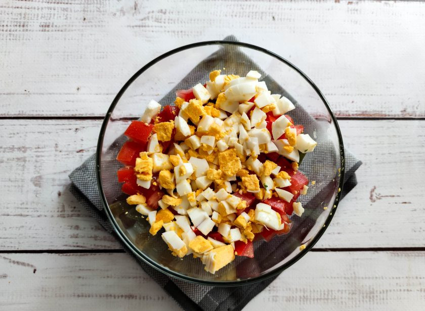 1. Этап. Салат Паради: Вареные яйца очистите от скорлупы, мелко нарежьте и выложите в тарелку.