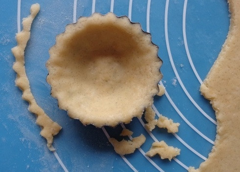 1. Этап. Тарталетки из песочного теста: Раскатываем охлажденное тесто в пласт толщиной примерно 4 мм. Вырезаем круги диаметром чуть больше, нежели диаметр формочек и распределяем тесто прижимая к дну и бортикам. Дно можно наколоть вилкой.