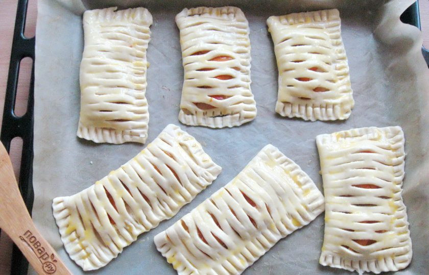 1. Этап. Слойки с творогом и абрикосами: Смажьте слойки взбитым яйцом и поставьте в разогретую до 180-190 градусов духовку.