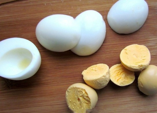 1. Этап. Фаршированные яйца со шпротами и красной икрой: 1. Яйца заливаю холодной водой, кладу щепотку соли и отвариваю после закипания 7 минут, затем охлаждаю под холодной водой и очищаю. Разрезаю каждое на 2 части, вынимаю желток.