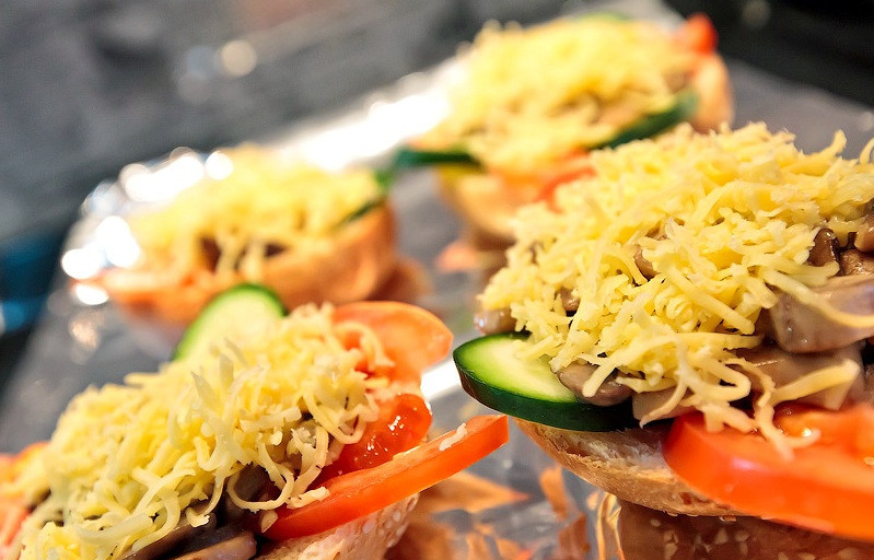 1. Этап. Бутерброды с шампиньонами и сыром: Посыпаем шампиньоны тертым на мелкой терке сыром.