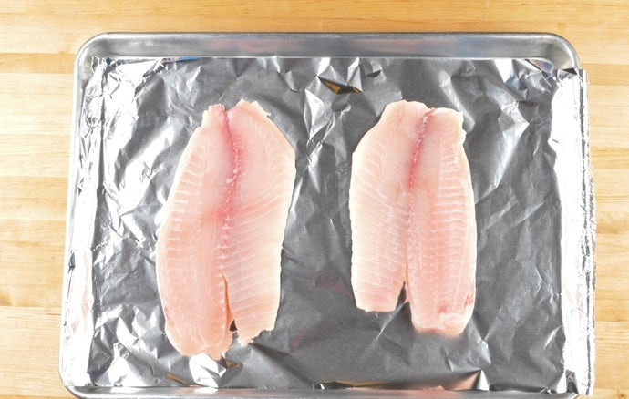 1. Этап. Тайские рыбные котлеты: 2. Филе выложите на противень с фольгой. Сбырзните его 1 ч. ложкой масла, а потом отправьте запекаться на 13 минут при 190 градусах в духовке.