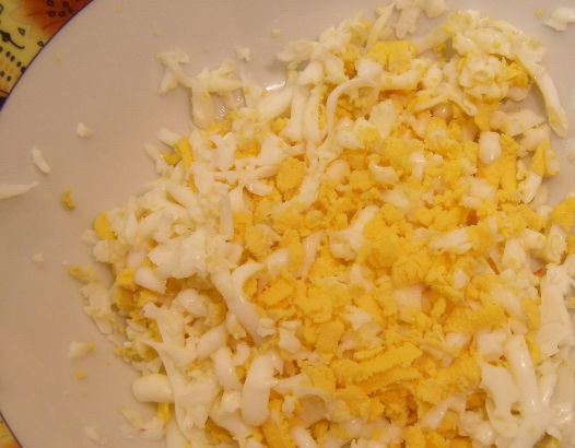 1. Этап. Салат Любимый с черносливом: Варёные яйца остыдите, почистите и натрите на крупной тёрке.