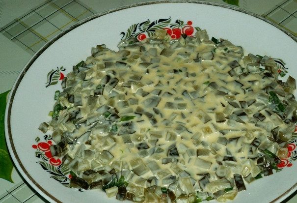 1. Этап. Салат с рыбными консервами: Смазываем огурцы слоем майонеза.