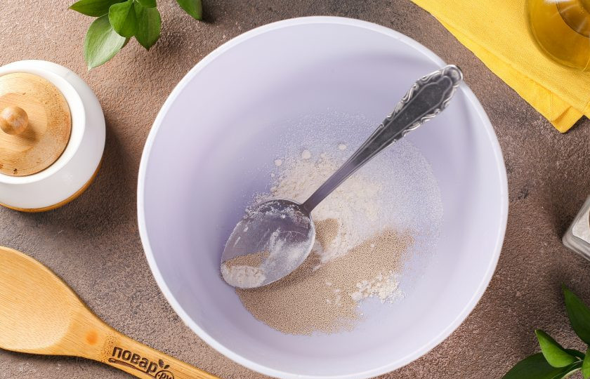 1. Этап. Пышные жареные пирожки на кефире с дрожжами: В глубокой миске соедините 1 ст.л. сахара, 1 ст.л. муки и дрожжи.