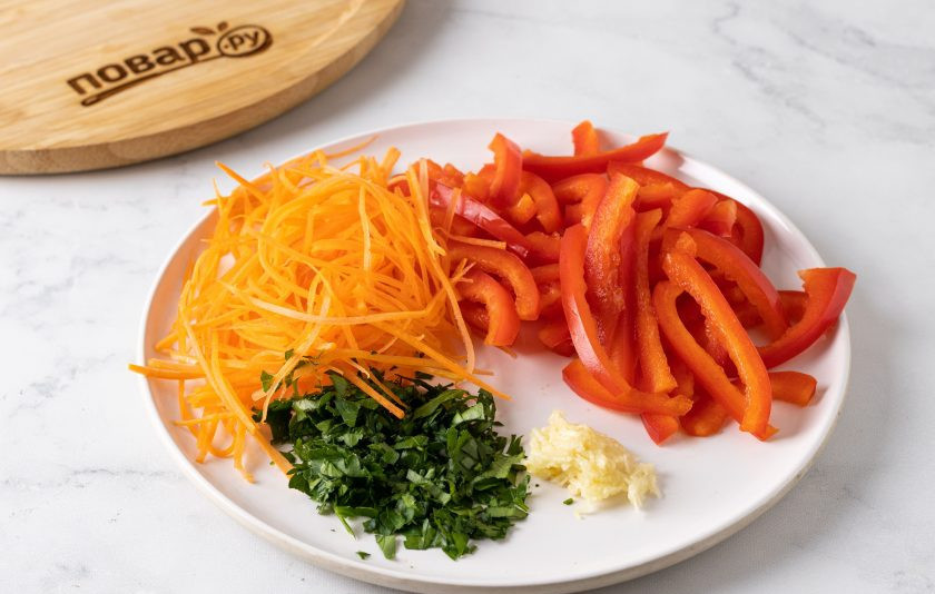 1. Этап. Маринованная капуста с красным перцем: Морковь натрите на терке для моркови по-корейски. Перец нарежьте соломкой. Петрушку мелко порубите. Чеснок пропустите через пресс.