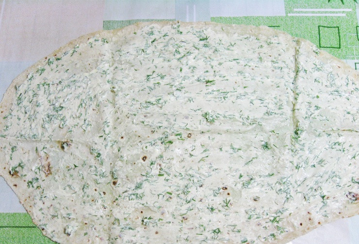 1. Этап. Рулет из лаваша с консервированной рыбой: Теперь мы берем один лаваш и выкладываем его на ровную поверхность, смазываем лаваш равномерно 1/3 частью майонеза с зеленью.