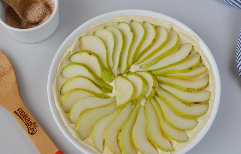 1. Этап. Грушевый пирог: Вымойте груши, удалите сердцевины, порежьте груши дольками и выложите поверх теста.