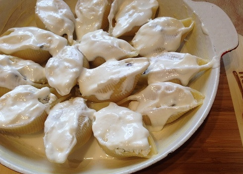 1. Этап. Сладкие конкильони с творогом: 6. Столовую ложку сметаны разведем в половине стакана воды и выливаем в форму. Оставшейся сметаной смажем конкильони.