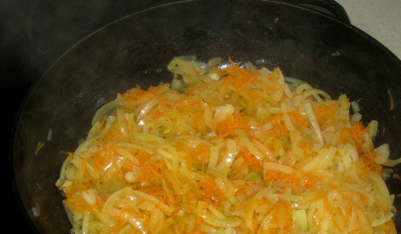 1. Этап. Тушеная говядина на сковороде: В сковороду наливаем немного масла. Выкладываем лук с морковью, заливаем стаканом воды. Бросаем специи и лавровый лист. При желании можно добавить базилик. Тушим на тихом огне 10 минут.