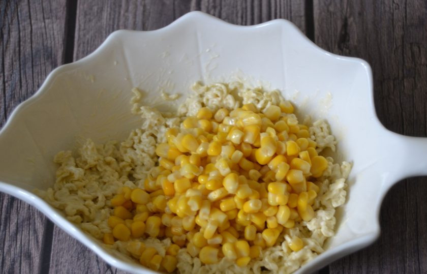 1. Этап. Салат с Дошираком: Добавьте консервированную кукурузу.