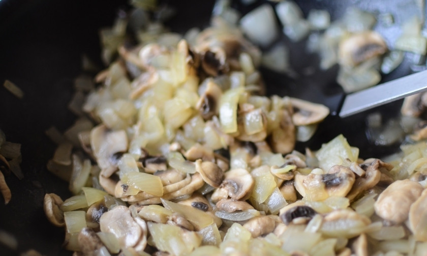 1. Этап. Тушеные овощи с сыром: Сначала обжарьте немного лук, пока он не станет прозрачным, затем добавьте шампиньоны. И потушите всё вместе около пяти минут.