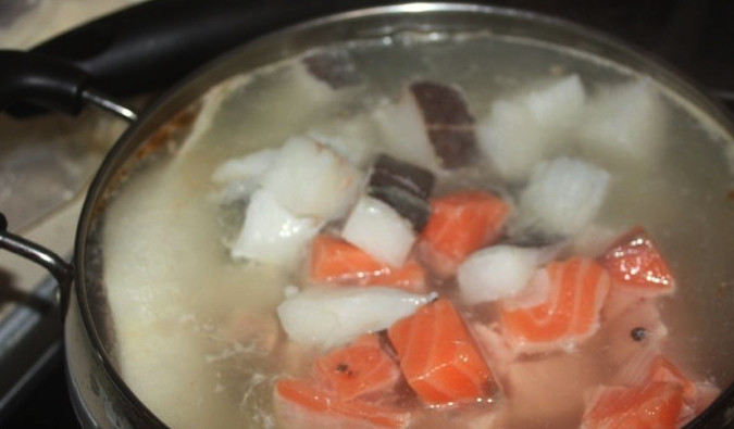 1. Этап. Царская уха (старинный рецепт): Лук очистите от шелухи и разрежьте его на две половинки. В кастрюлю налейте 1,5 литра воды и вскипятите её. Посолите по вкусу и отправьте туда картофель и морковь. Через 10 минут положите туда лук, а ещё через 10 минут — рыбу. Бульон с рыбой должен вариться ещё 5 минут.