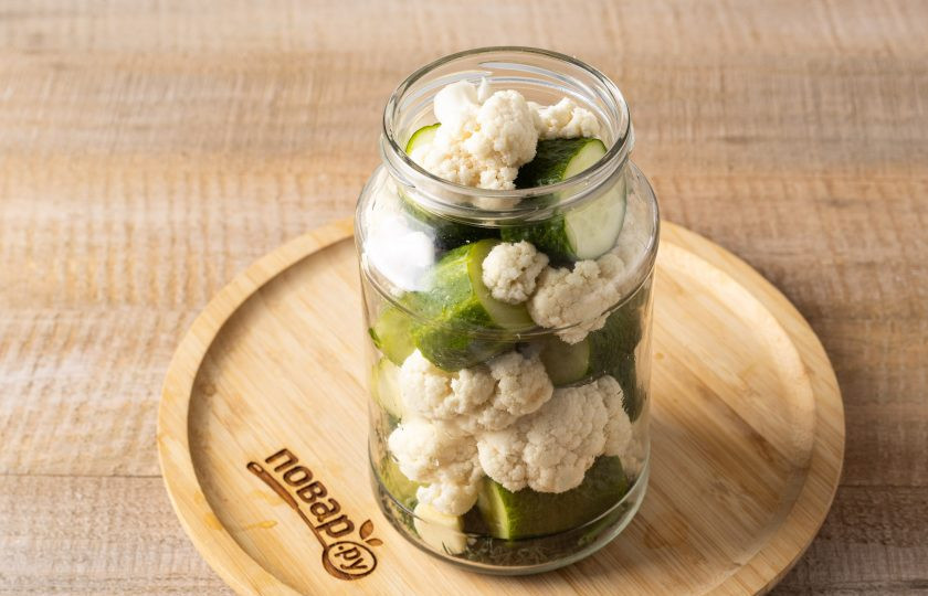1. Этап. Цветная капуста маринованная с огурцами на зиму: Заполните банку огурцами и цветной капустой.