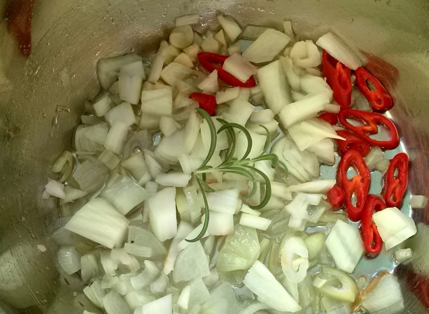 1. Этап. Биск из тыквы: Помыть, очистить и нарезать овощи: тыкву и лук – небольшими кубиками, чеснок — тонкими ломтиками, перец — кольцами. В средней кастрюле нагреть масло на среднем огне. Добавить лук, чеснок, веточку розмарина и жгучий перец. Пассеровать 5 минут до мягкости лука. Если нет свежего розмарина, замените его сушеным.