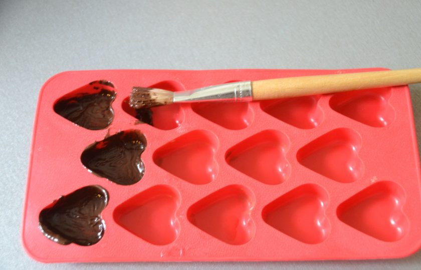 1. Этап. Конфеты Вишня в шоколаде: Для приготовления фигурных конфет смажьте силиконовую форму растопленным шоколадом. Поставьте в прохладное место на 15-20 минут, так повторите три раза, чтобы сформировался достаточно прочный слой корпуса конфет.