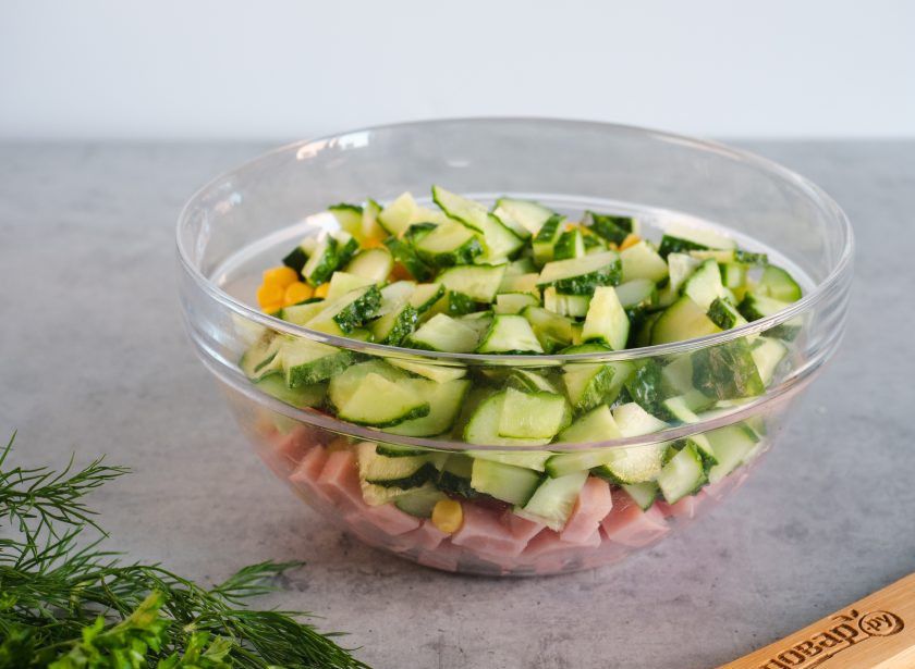 1. Этап. Салат с ветчиной, яйцом и кукурузой: Следом добавьте нарезанные кусочками огурцы.