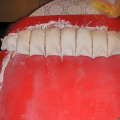 1. Этап. Мини пицца из слоеного теста: 6. Скатанный рулет разрезать на одинаковые кусочки. Размером примерно по 2-3 см.