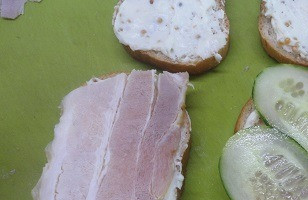 1. Этап. Бутерброд с запеченным перцем: Смазать этой смесью все кусочки хлеба. На два кусочка выложить ломтики грудинки и тонко нарезанный огурец.