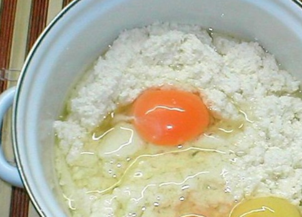 1. Этап. Cыр сулугуни в домашних условиях: Когда сыворотка стечет, перекладываем сырную массу в другую кастрюлю, добавляем яйца, мягкое масло и соль. Перемешиваем и ставим на огонь на 10-15 минут.