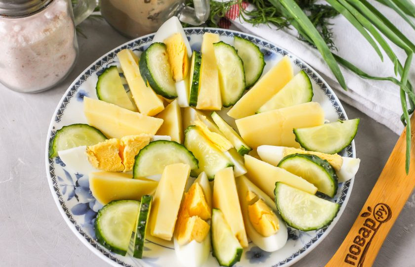 1. Этап. Салат с икрой мойвы: Промойте свежий огурец в воде, срежьте хвостики с овоща и нарежьте его половину кружочками или брусочками. Выложите на тарелку.