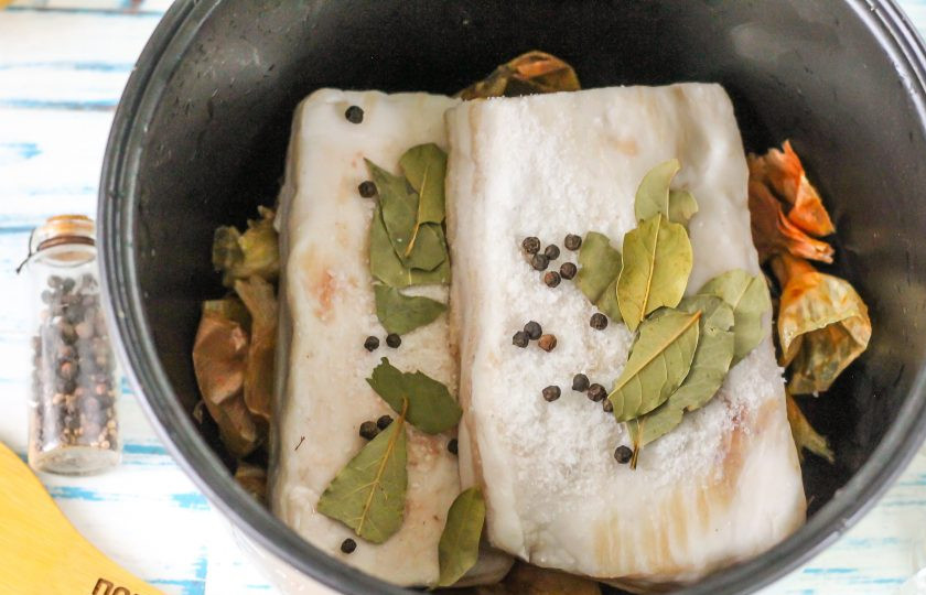 1. Этап. Сало в луковой шелухе в мультиварке: Всыпьте на сало соль, горошины черного перца, выложите лавровые листья. По желанию можете добавить пару нарезанных очищенных зубчиков чеснока.