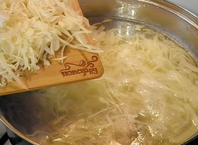 1. Этап. Капустный суп с курицей: Добавьте капусту и лук. Варите 25 минут до полной готовности супа. Откорректируйте на соль.