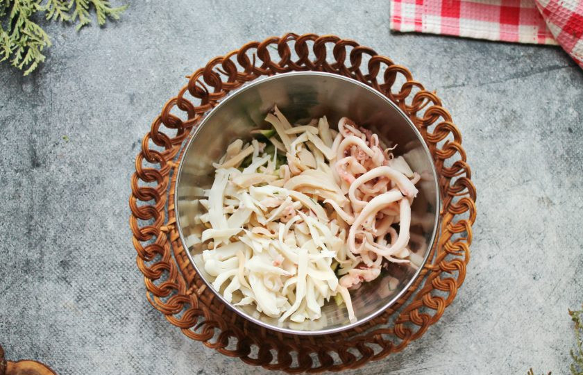 1. Этап. Салат с огурцом, кальмаром и яблоком: Кальмары порежьте тонкой соломкой и вместе со щупальцами выложите к огурцу.