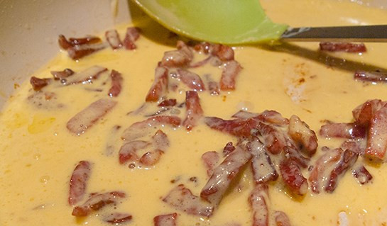 1. Этап. Спагетти под соусом Карбонара: Выливаем смесь яиц и сыра на еще теплую, но не горячую сковороду с беконом. Всё перемешиваем. Важно: не выливайте смесь на горячую сковороду, так как яйца просто-напросто поджарятся, соус испортится.