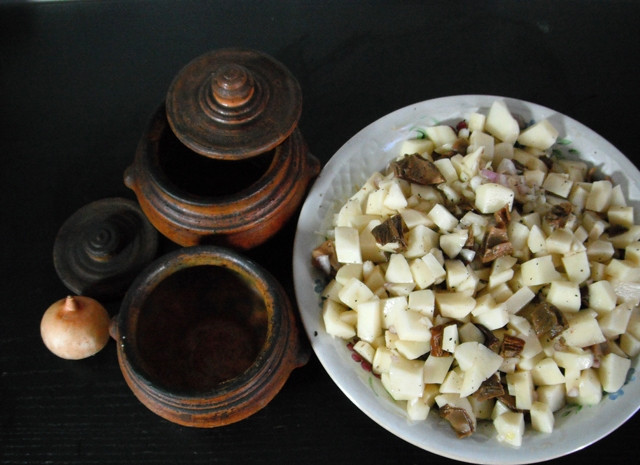 1. Этап. Курица с грибами в горшочке: Соединить картофель, грибы и лук, посолить, поперчить, перемешать.