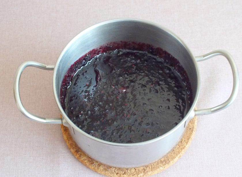 1. Этап. Варенье из черноплодной рябины с апельсином: Перелейте содержимое чаши в кастрюлю с толстым дном. Поставьте на медленный огонь. Варите с момента закипания 40 минут. После снимите, охладите. Выдержите 6-8 часов. После поставьте опять на медленный огонь и проварите с момента закипания 20 минут. Снимите с огня.