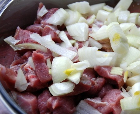 1. Этап. Гуляш в микроволновке: Мясо моем, нарезаем маленькими кубиками и выкладываем в посуду для микроволновки. Поверх мяса выкладываем нарезанный лук.