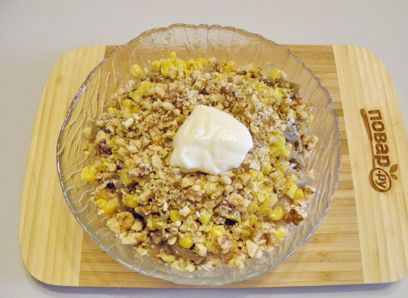 1. Этап. Салат Золотой петушок: Орехи растолките в ступке, положите в салат. Заправьте его не большим количеством майонеза. Соль и перец черный молотый — по вкусу.