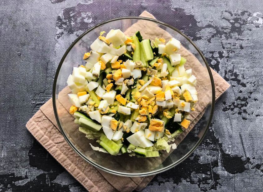 1. Этап. Салат с пекинской капустой и мидиями: Яйцо очистите от скорлупы, мелко нарежьте и выложите в тарелку.