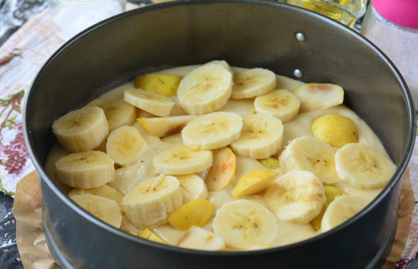 1. Этап. Бананово-грушевый пирог: Смажьте форму маслом или выстелите пергамент, налейте тесто и разровняйте поверхность. Сверху выложите кусочки груши и банана. В процессе выпекания фрукты немного утонут в тесте.